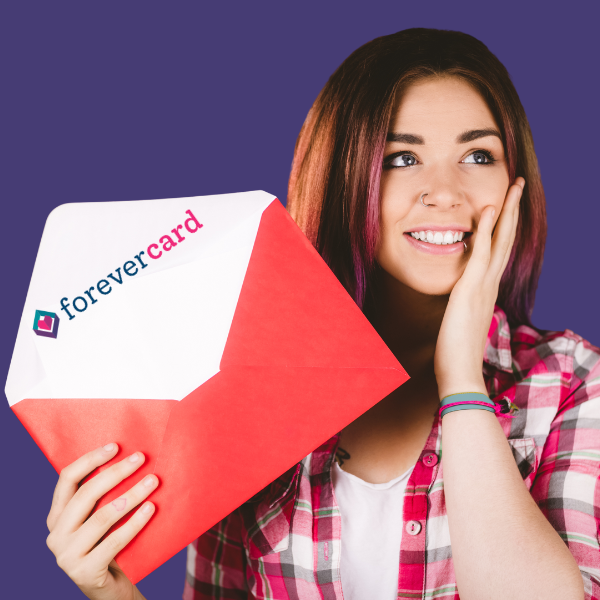 Smiling young woman holding a red envelope with a Forever Card logo, wearing a plaid shirt against a purple background.